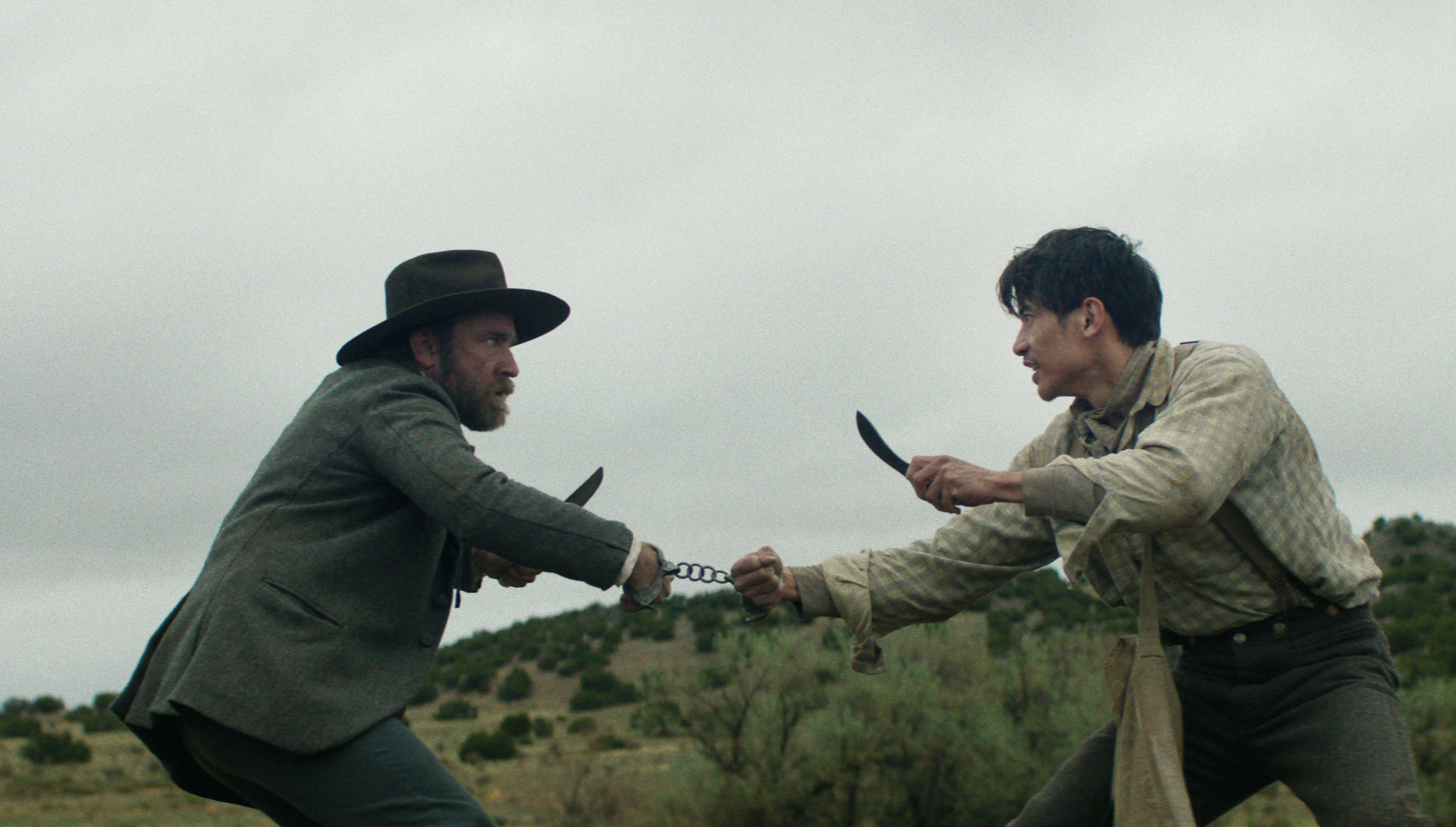 Ben Foster and Manny Jacinto face off with knives while chained together in The Stalemate.