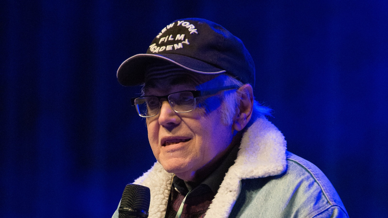 Walter Koenig speaking into a microphone at a fan convention in May 2016.